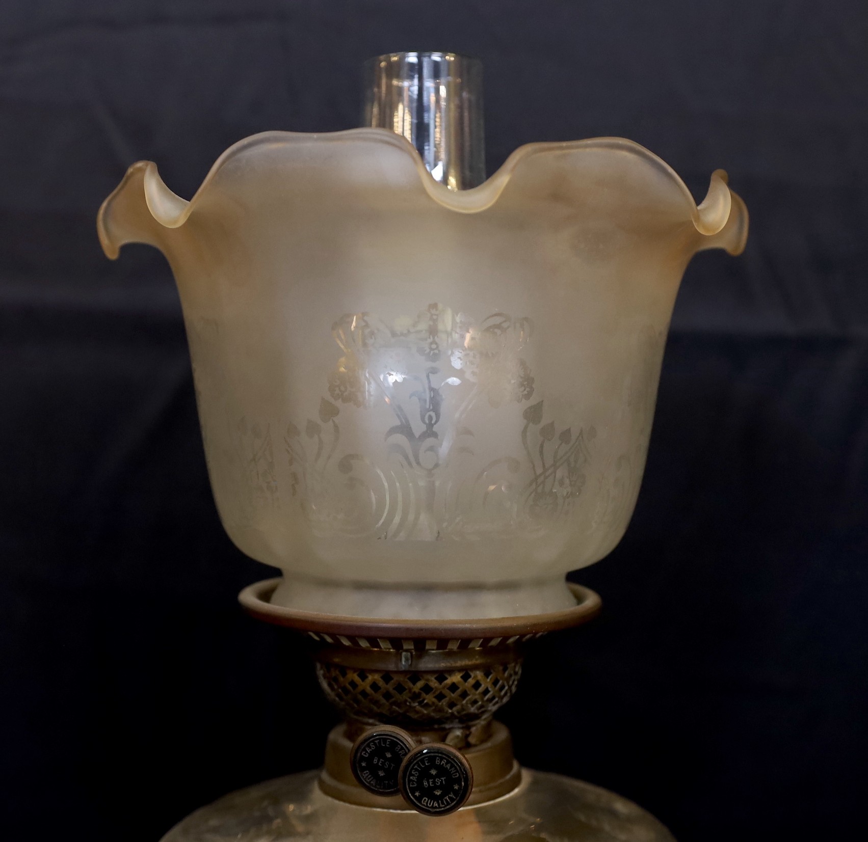 An Edwardian brass Corinthian column oil lamp with cut glass reservoir, Castle Brand mechanism and etched glass shade, height overall 86cm.